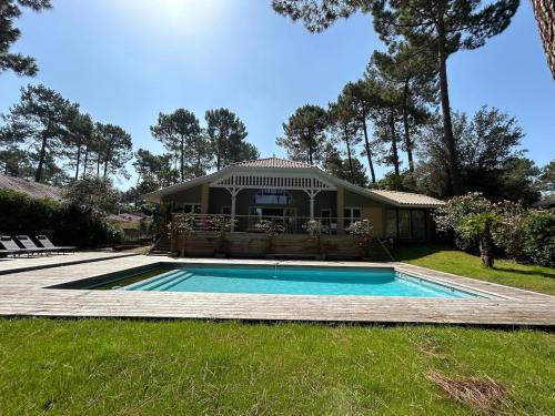 une maison avec une piscine dans la cour dans l'établissement Villa 10pers avec piscine privée, à Lacanau