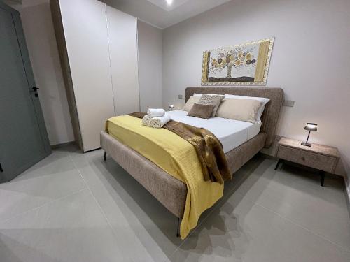 a bedroom with a bed with a yellow blanket on it at Elysium - Luxury Holiday Home in Lendinuso