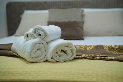 a pile of towels sitting on top of a bed at Elysium - Luxury Holiday Home in Lendinuso