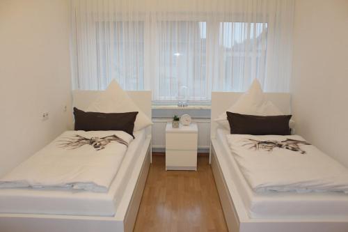 - 2 lits blancs dans une chambre avec fenêtre dans l'établissement Ferienhaus MeinWeg, à Wassenberg