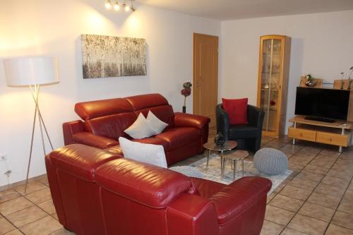 un salon avec un canapé en cuir et une télévision dans l'établissement Ferienhaus MeinWeg, à Wassenberg