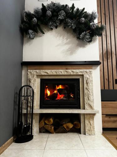a fireplace with a christmas wreath on it at Avelov Art Studio in Pamporovo