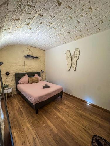 - une chambre avec un lit recouvert de draps roses dans l'établissement La Suite du Peyrou - 50m de l'Arc de Triomphe, à Montpellier