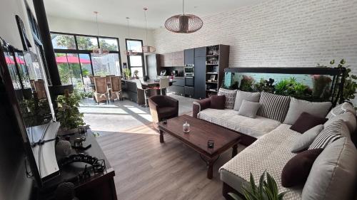 un salon avec un canapé et une table dans l'établissement Maison de 102m² sur terrain clos terrasse Jacuzzi, à Le Tour-du-Parc