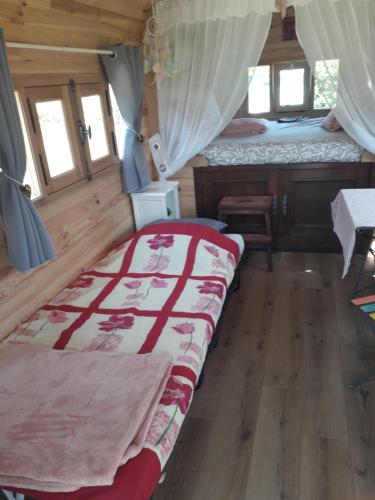 a bedroom with two beds in a room at La roulotte des Trois Arbres in Oradour-sur-Glane