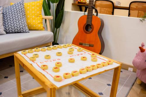 a table with a tray of donuts on it with a guitar at Skudai Tun Aminah Cozy Home - Sutera Mall 6 mins in Skudai