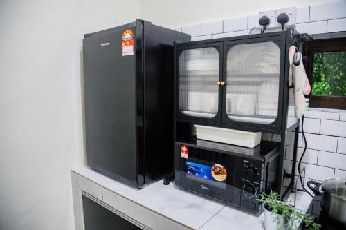 a microwave sitting on top of a counter at Skudai Tun Aminah Cozy Home - Sutera Mall 6 mins in Skudai