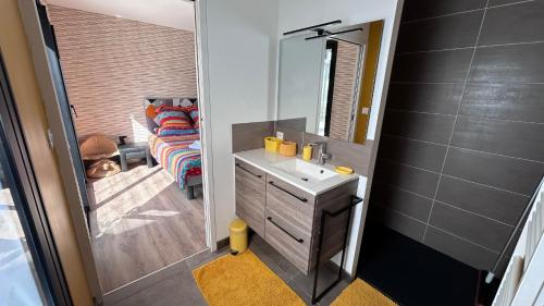 une salle de bain avec un lavabo, un miroir et un canapé dans l'établissement Maison de 102m² sur terrain clos terrasse Jacuzzi, à Le Tour-du-Parc