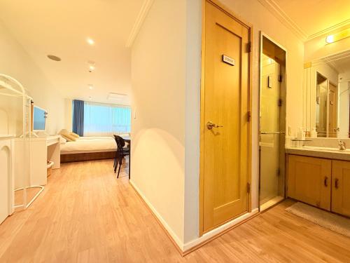 Un baño con una puerta que da a un dormitorio. en Oasis Hongdae City View, en Seúl