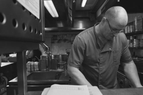 a man standing in a kitchen preparing food at Hotel Sonnalp in Kirchberg in Tirol