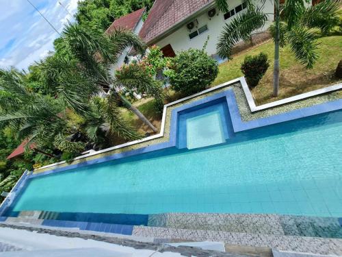a swimming pool in front of a house at Tablas Seaview Homestay in Ferrol