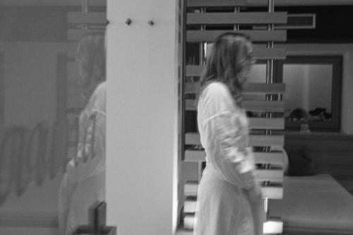 a woman in a white dress walking in a room at Hotel Sonnalp in Kirchberg in Tirol
