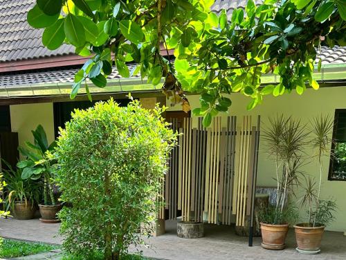 a wooden fence in front of a house with plants at สวนไมตรีจิต รีสอร์ท in Ban Khlong Si