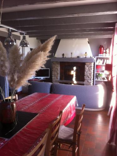 une salle à manger avec une table rouge et une cheminée dans l'établissement maison quercynoise FIGEAC, à Lunan