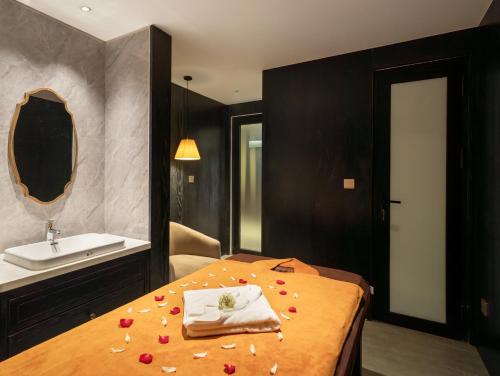 a bathroom with a bed with flowers on it at Luxe Paradise Premium Hotel and Spa in Hanoi
