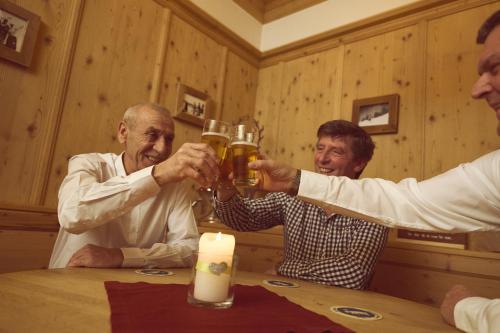 a group of men drinking beer at a table at Hotel Sonnalp in Kirchberg in Tirol
