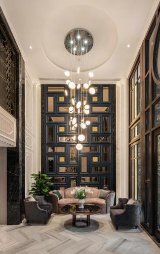 a living room with a couch and a chandelier at Luxe Paradise Premium Hotel and Spa in Hanoi
