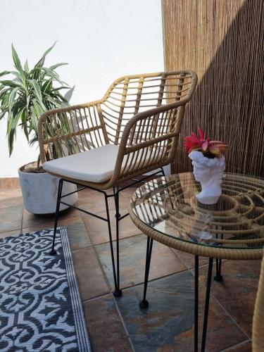 a patio with two chairs and a table with a vase of flowers at Featherbed in Hermanus
