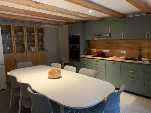 - une cuisine avec une table et des chaises blanches dans l'établissement village house, à Val Cenis
