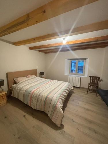 une chambre avec un lit, une chaise et une fenêtre dans l'établissement village house, à Val Cenis