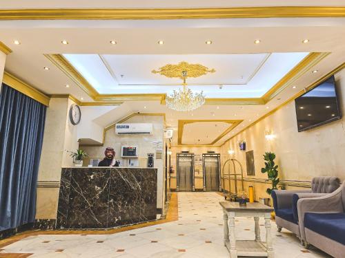 a lobby of a hotel with a man standing at the counter at فندق مكارم روز 1 Mkarem Rose Hotel in Makkah
