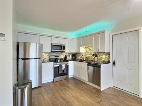 a kitchen with white cabinets and a stainless steel refrigerator at Crescent Beach 1011 #1 in Sarasota