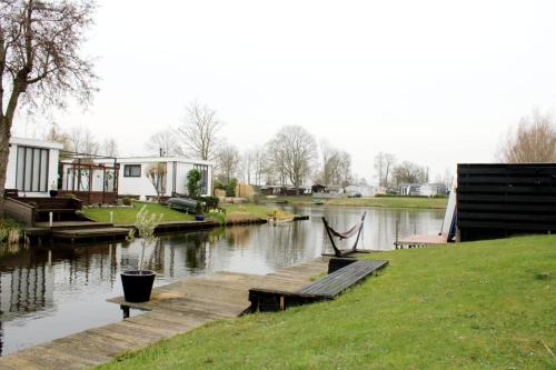 Blick auf einen Fluss mit einem Dock und Häusern in der Unterkunft Vakantie Chalet T30 - Makkum in Makkum