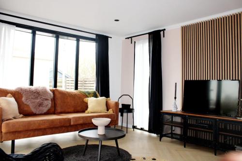 ein Wohnzimmer mit Couch und Flachbildfernseher in der Unterkunft Vakantie Chalet T30 - Makkum in Makkum