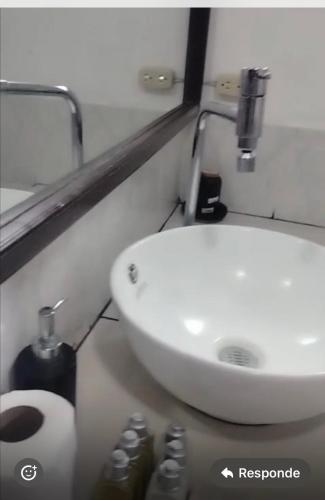 May Apartamento في سان سلفادور: حمام مع حوض غسيل أبيض ومرحاض