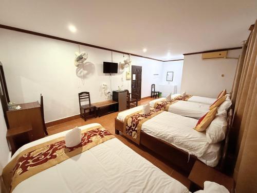 a hotel room with two beds and a television at Vangvieng Sisavang Hotel in Vang Vieng