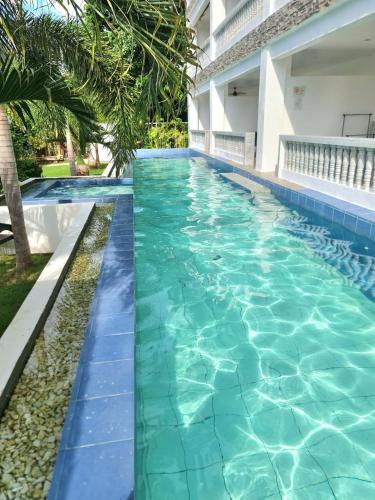 a swimming pool at a resort with blue water at Tablas Seaview Homestay in Ferrol