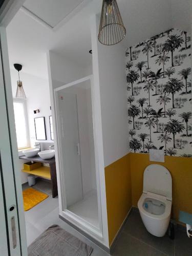 La salle de bains est pourvue de toilettes avec des palmiers sur le mur. dans l'établissement Les 2 moi s'L, à Sauzon