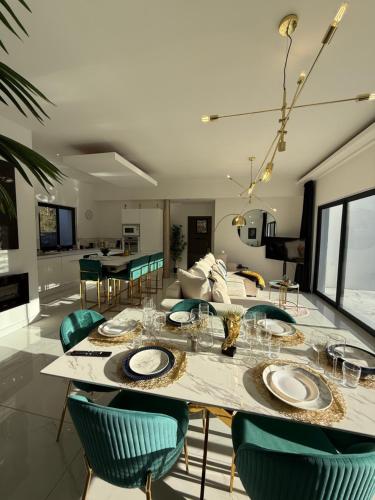 a dining room and living room with a table and chairs at Magnifique maison vue spa détente nature à Limoux in Limoux
