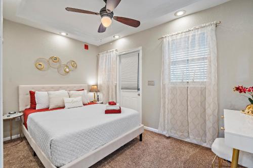 Un dormitorio con una cama blanca y un ventilador de techo. en Romance in the City 1 Bdrm Studio in Downtown St Pete, en San Petersburgo