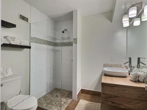 Un baño con ducha, inodoro y lavabo. en Crescent Beach 1015 #2, en Sarasota