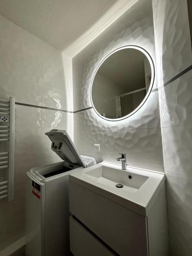 une salle de bain avec un lavabo et un miroir dans l'établissement Appartement T2 - Cosy 400m des thermes, à Cazaubon