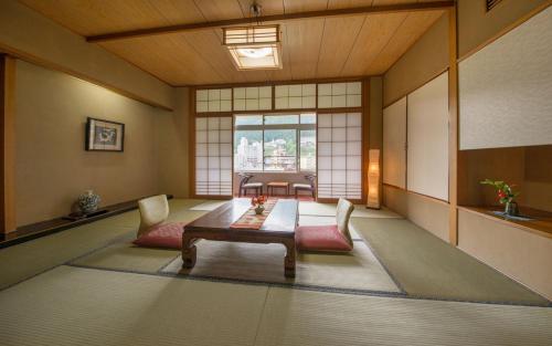 a room with a table and chairs and a window at Yamagataya in Gero