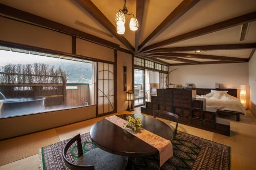 a bedroom with a bed and a table and chairs at Yamagataya in Gero