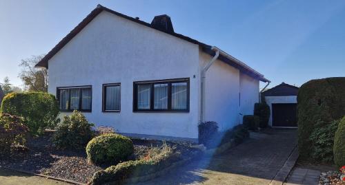 a white house with black windows and bushes at Ferienhaus MeinWeg in Wassenberg