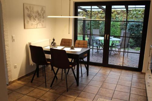 a dining room with a table and chairs and a patio at Ferienhaus MeinWeg in Wassenberg