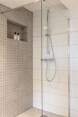 a bathroom with a shower with a glass door at B&NB The Barnhouse in Bergambacht