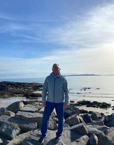 a man standing on some rocks by the water at Coastal Gem 10 Mins from Dublin Airport in Donabate