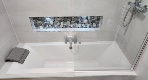 a small bathroom with a sink with a shower at Coastal Gem 10 Mins from Dublin Airport in Donabate