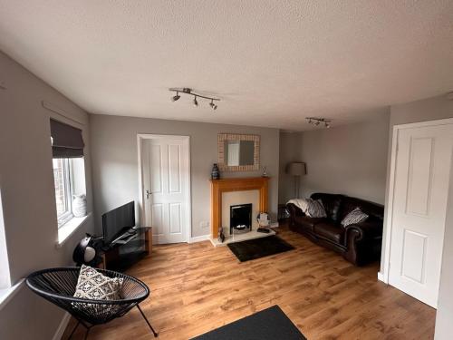 a living room with a couch and a fireplace at A Cozy One Bedroom Flat for Two Guests in Carlisle