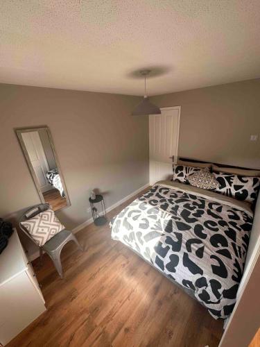 a bedroom with a black and white bed and a mirror at A Cozy One Bedroom Flat for Two Guests in Carlisle