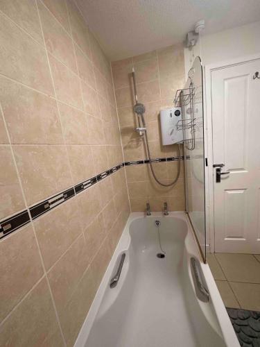 a bath tub in a bathroom with a shower at A Cozy One Bedroom Flat for Two Guests in Carlisle