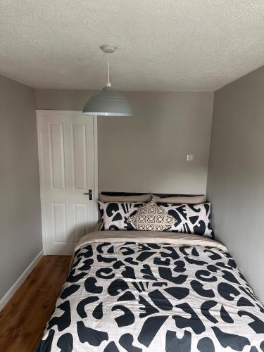a bedroom with a bed with a black and white comforter at A Cozy One Bedroom Flat for Two Guests in Carlisle