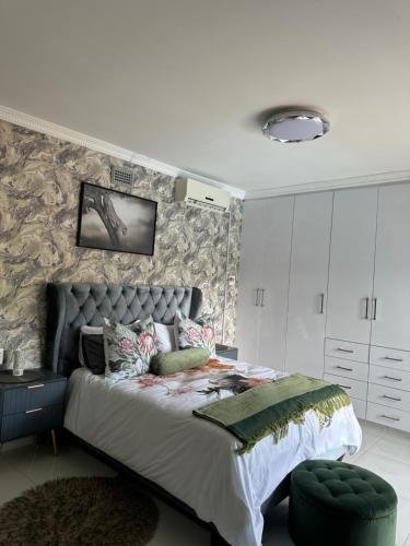 a bedroom with a large bed and a wall at The Azania Lux in Durban