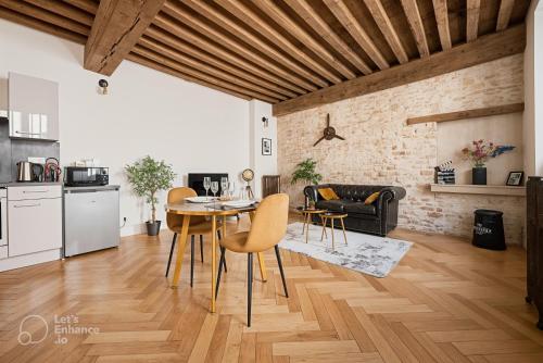 une cuisine et un salon avec une table et des chaises dans l'établissement Le Rousseau - Appartement & Suite en Hypercentre, à Dijon