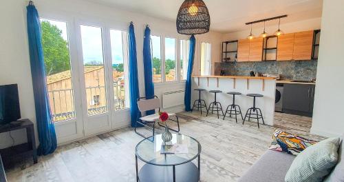 un salon avec un canapé et une table et une cuisine dans l'établissement Terrace - Quiet - Near ramparts, à Avignon